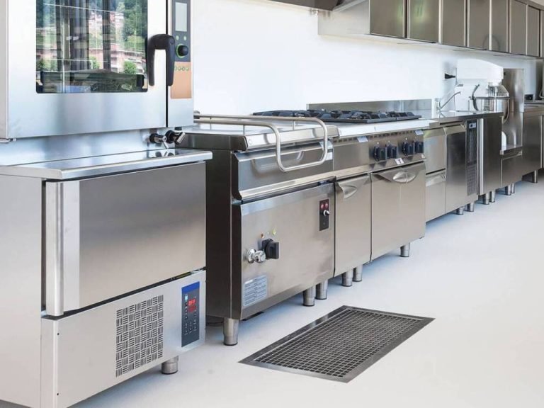 A spacious commercial kitchen featuring gleaming stainless steel appliances and ample workspace for food preparation.
