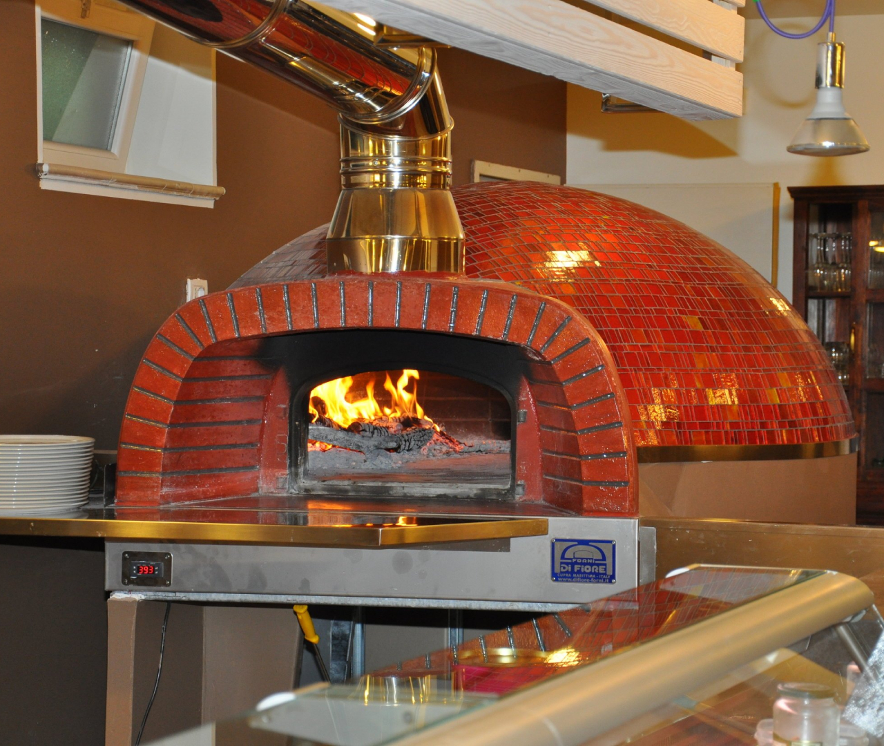 A warm brick oven with a glowing fire inside, radiating heat and inviting aromas of freshly baked bread.